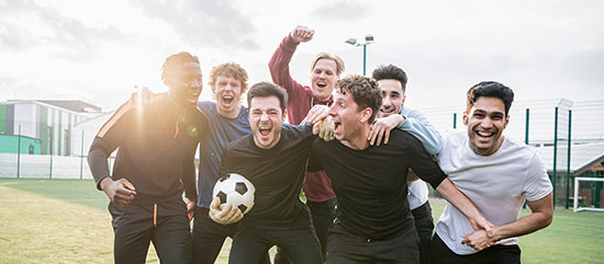Eine lokale Fußballmannschaft feiert gemeinsam auf dem Sportplatz.